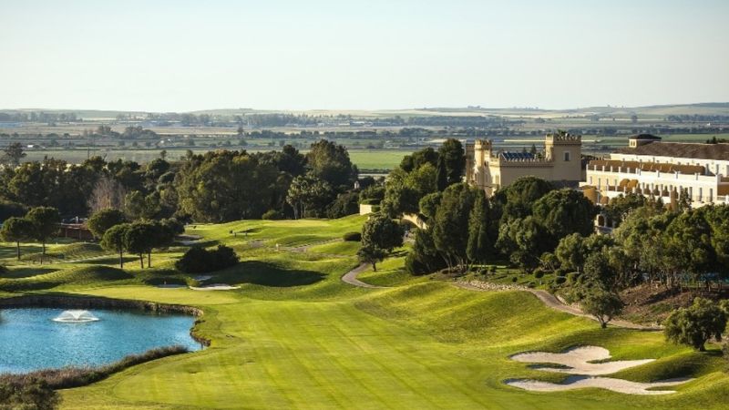 Golfbana vid Montecastillo med fairway, vatten, bunkrar och hotell i bakgrunden.